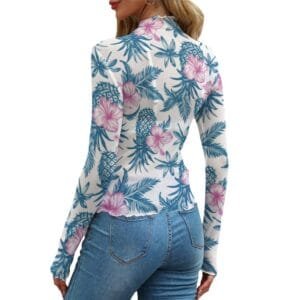 Woman modeling a sheer, long-sleeve women's upside down pineapple top with a subtle blue and pink tropical floral pattern.